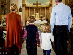 Família reunida na missa dominical, sinal da importância do domingo.