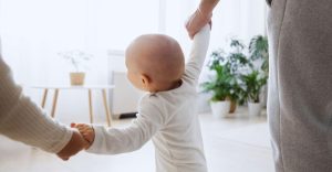 Mãos segurando um bebê como expressão do valor da vida.